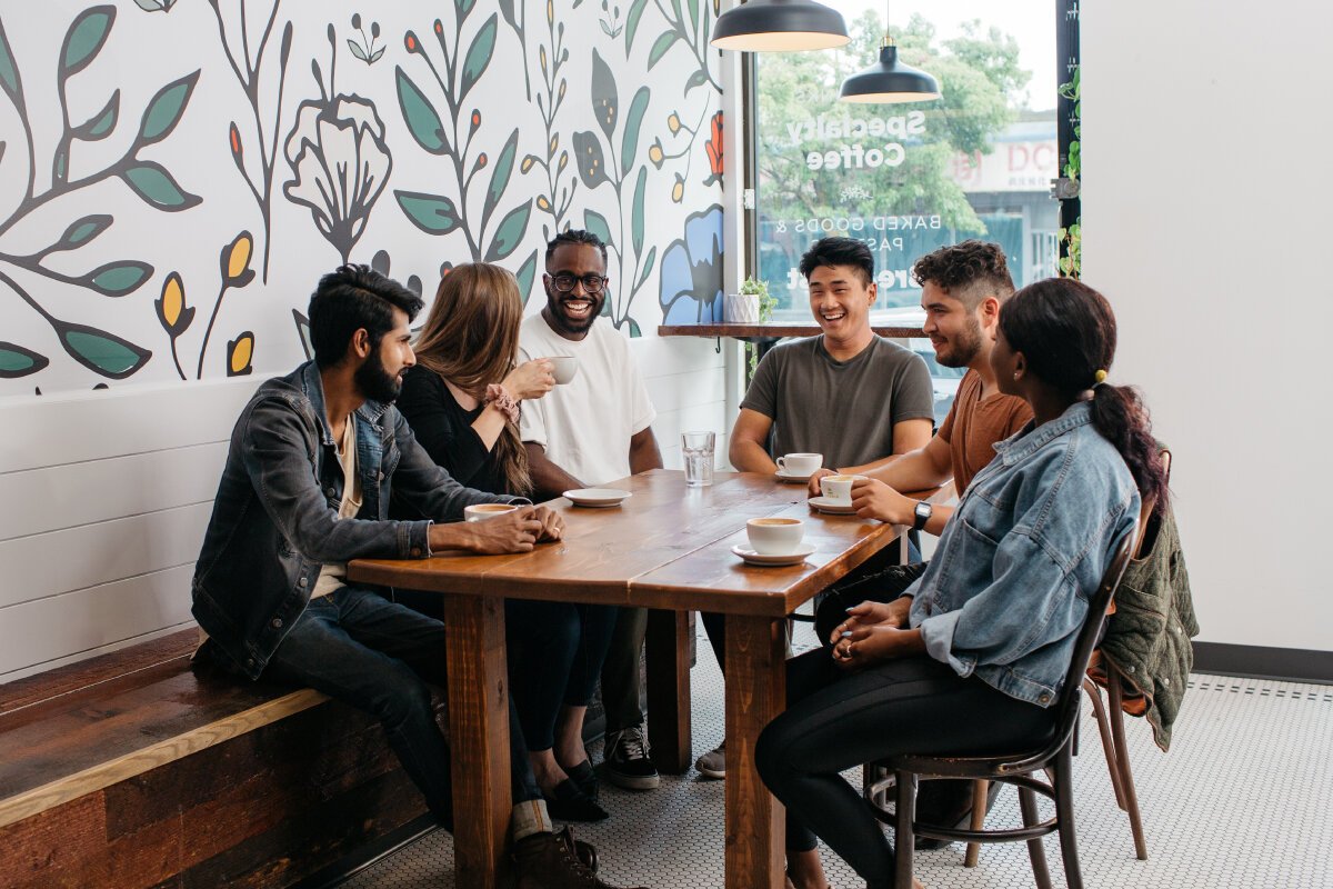 Illustrative multicultural group sharing coffee and conversation
